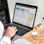 Person working on laptop at desk in workspace
